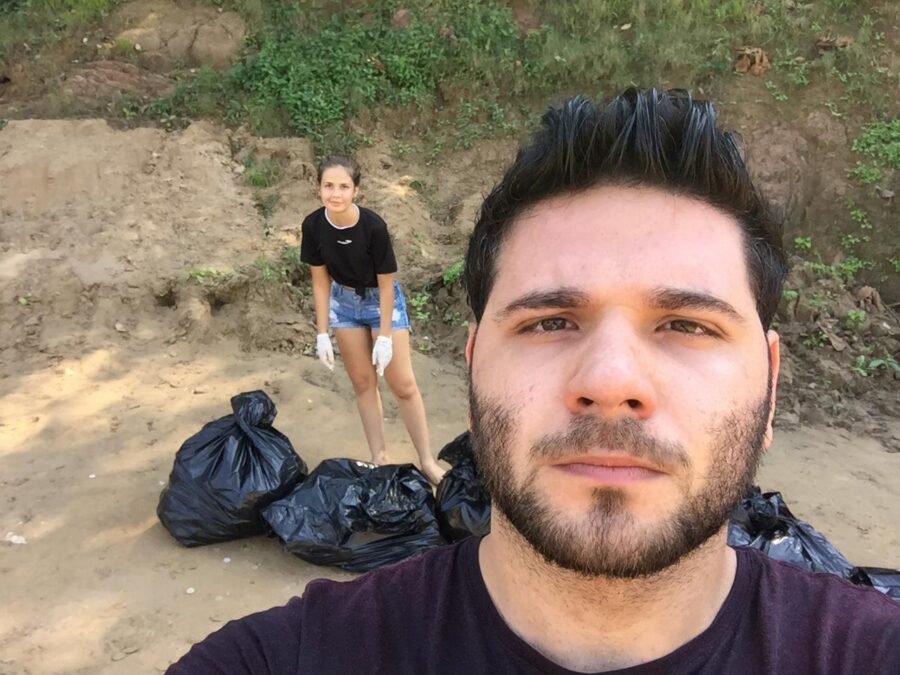 EXEMPLO: Jovem casal faz coleta de lixo em praia poluída por banhistas no Rio Yaco durante fim de semana movimentado em Sena Madureira
