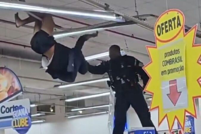 homem-e-contido-apos-se-pendurar-em-luminaria-de-supermercado.-video