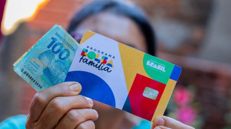 Beneficiária do Bolsa Família segurando cartão do programa.