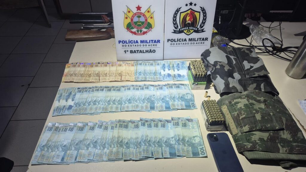 Policiais militares durante apreensão de munições e dinheiro em residência de Rio Branco.
