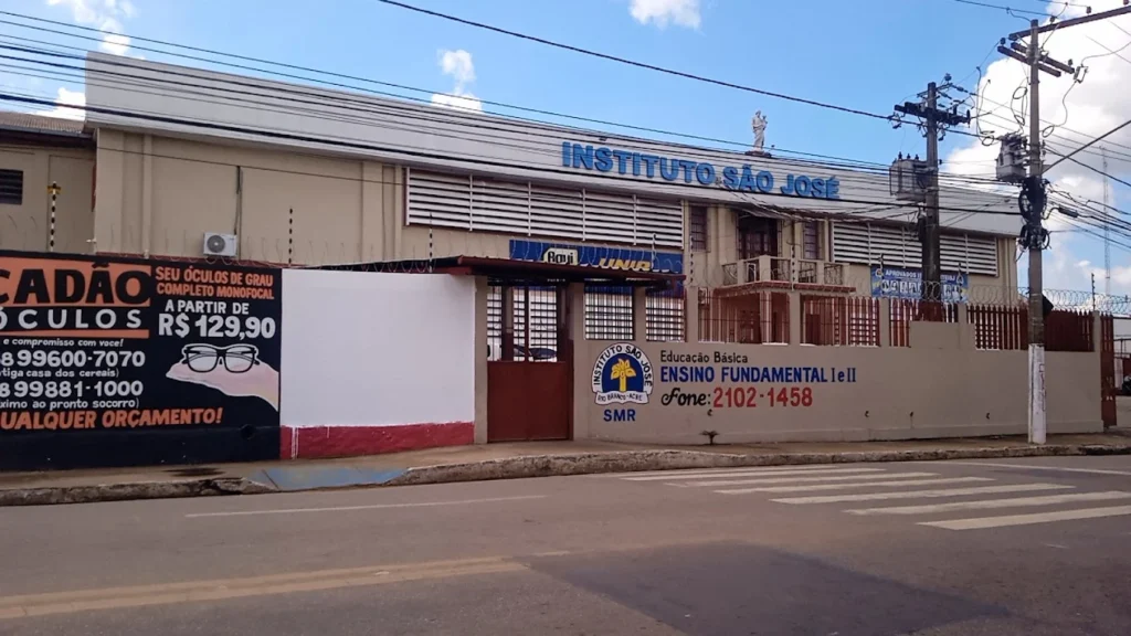 Fachada de escola em Rio Branco com presença policial após ataque e investigação do MPAC