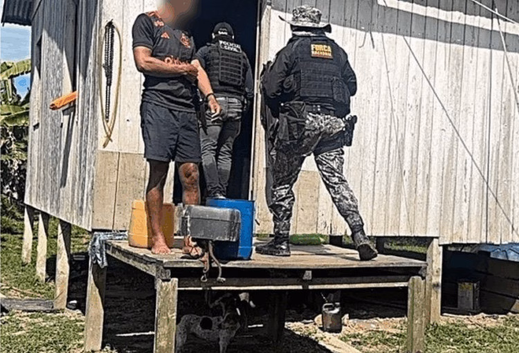 Dois policiais civis armados adentrando a residência de um suspeito durante cumprimento de mandado no Acre.