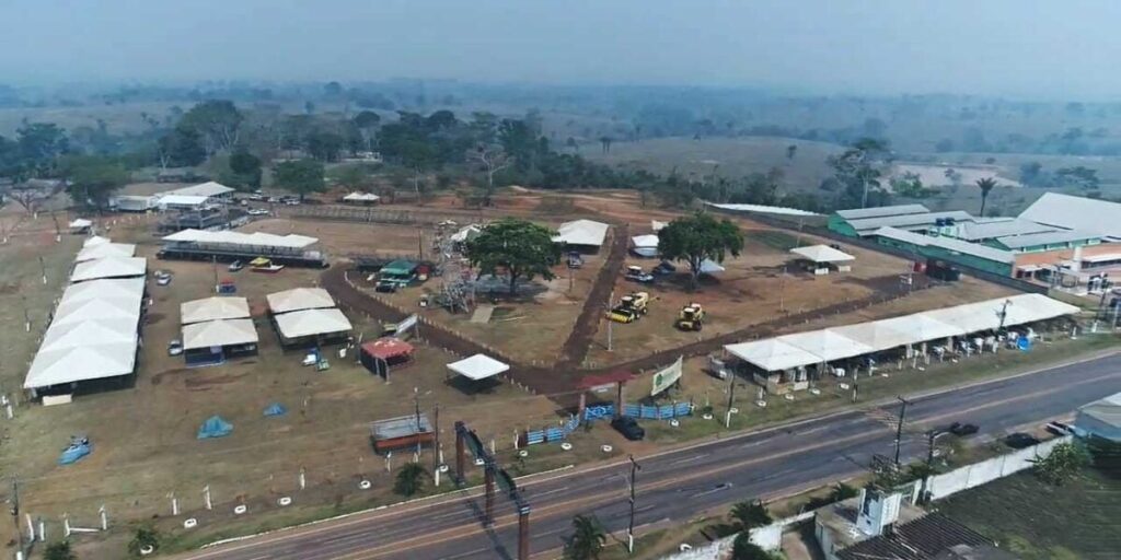 Público em feira agropecuária durante a ExpoQuinari em Senador Guiomard, com estandes, movimentação de visitantes e ambiente de exposição rural e cultural.