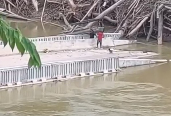 Moradores furam bloqueio e atravessam canoa sobre ponte destruída em Sena