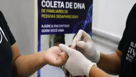 Profissional pericial segurando material de coleta de DNA para banco de dados genéticos.