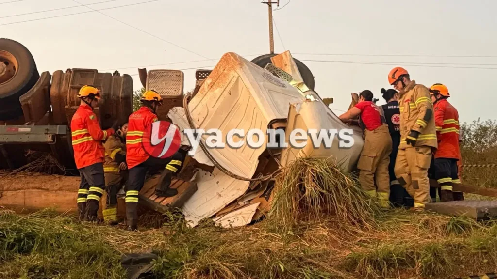 Caminhão carregado de toras tombado no acostamento da rodovia Transacreana durante operação de resgate dos Bombeiros.