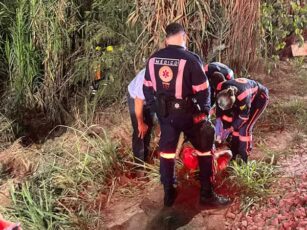 Veículo acidentado fora da pista após descer ribanceira e capotar na BR-364, com equipes de resgate do Corpo de Bombeiros no local.