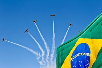 Aeronave de resgate vermelha em sobrevoo sobre a área urbana durante evento oficial.