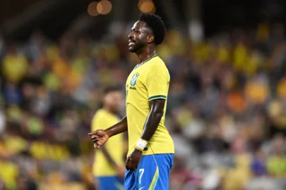 Atacante Vinicius Junior em campo vestindo a camisa da Seleção Brasileira durante partida.